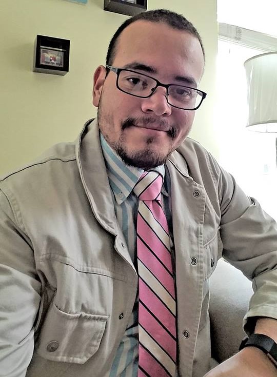 Portrait of Cristofer Joan Gutierrez wearing a white coat, pink striped tie, and light blue shirt.